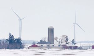 A farm stands in the foreground as some of the 45 wind turbines at the Bornish Wind Energy Centre stand in the distance near Parkhill. (Free Press file photo)