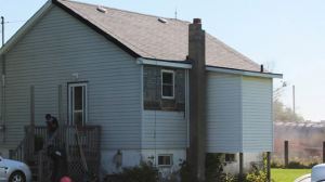 A young boy is seen covering his nose and mouth as he exits his home July 23. A plume of concrete dust travelled from a nearby construction site, sending five to hospital.