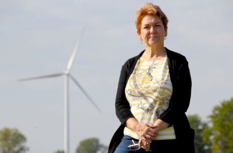 Betty Konc is pictured in Wainfleet with an industrial wind turbine behind her. (Greg Furminger/Welland Tribune/Postmedia Network)