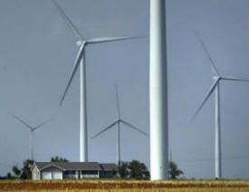 house surrounded by wind turbines